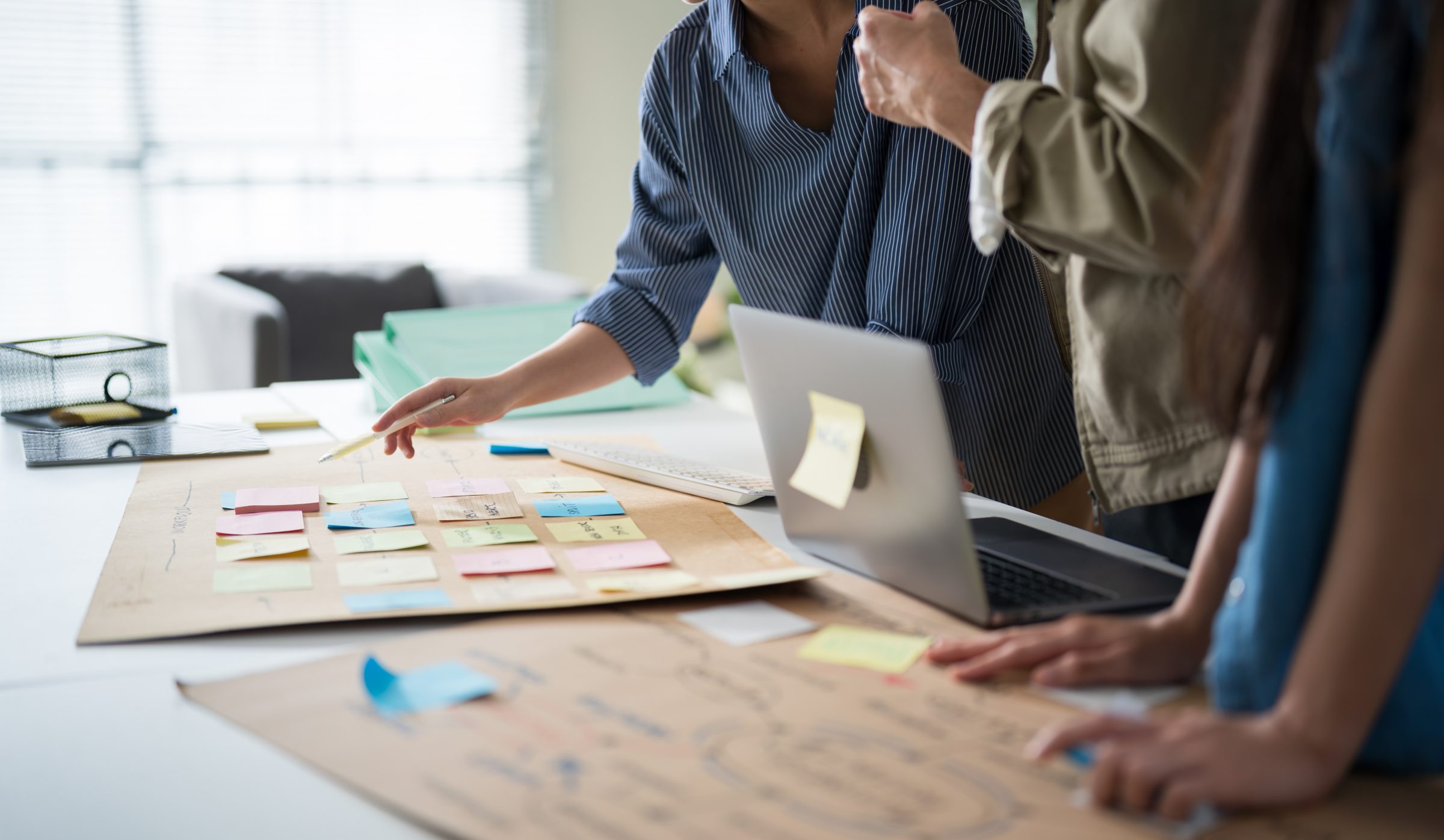 Project team planning with sticky notes and a laptop